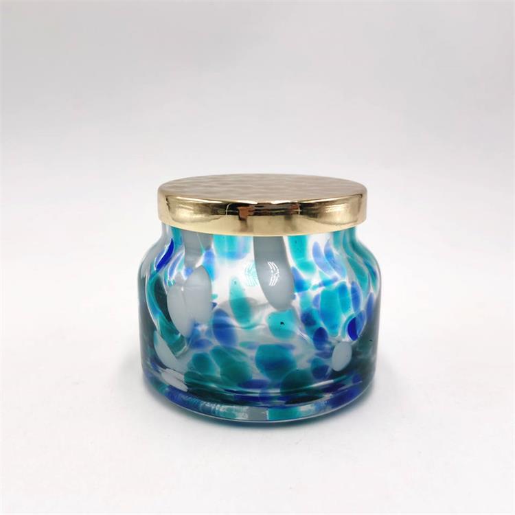 Empty spotted glass storage jar with metal lid